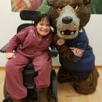 Woman in wheelchair posing with Bears mascot